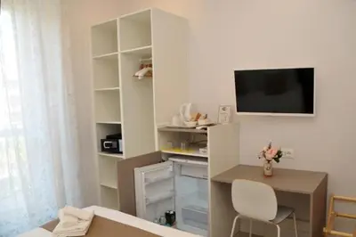 a white room with a desk and a tv in it at MIGDAL Luxury Suites Roma Porta Portese in Rome