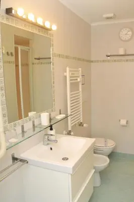 a bathroom with a sink and a toilet and a mirror at MIGDAL Luxury Suites Roma Porta Portese in Rome