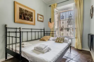 a bedroom with a bed with white sheets and a window at 
