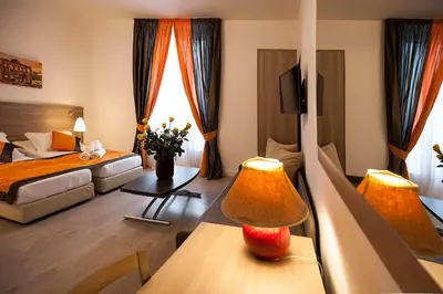 a hotel room with a bedroom with a bed and a table at Roman Holidays cuore dell'Impero in Rome