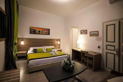 a small bedroom with a bed and a desk at Roman Holidays cuore dell'Impero in Rome
