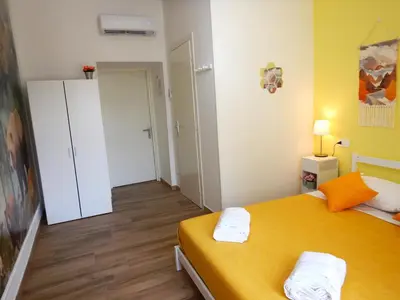 a small room with a yellow bed and a closet at My Dream in Rome in Rome