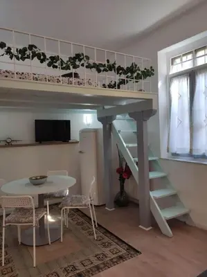 a living room with a loft bed with a table and a tableablish at Tranquillità a Roma! in Rome