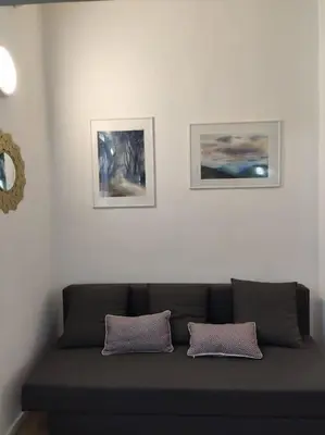 a couch in a room with three pictures on the wall at Tranquillità a Roma! in Rome