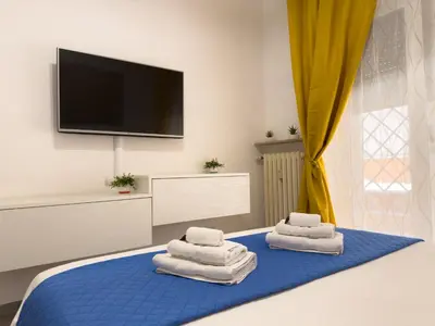 a room with two towels on a bed with a flat screen tv at Toto Vatican House in Rome