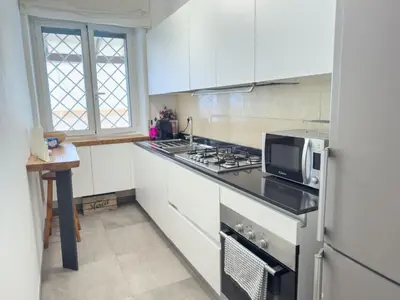 a kitchen with white cabinets and a stove top oven at Toto Vatican House in Rome