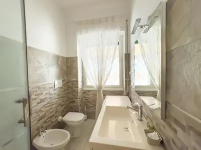 a bathroom with a sink and a toilet and a mirror at Toto Vatican House in Rome