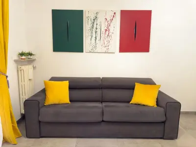 a brown couch with two yellow pillows in a room at Toto Vatican House in Rome