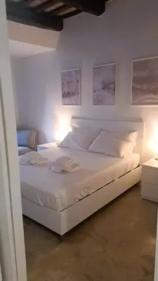 a white bed in a room with two lamps at San Cosimato cozy flat in Rome
