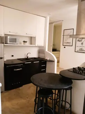a kitchen with two black tables and a microwave at San Cosimato cozy flat in Rome