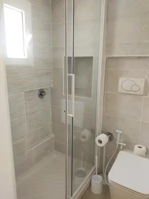 a bathroom with a glass shower with a toilet at San Cosimato cozy flat in Rome
