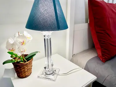 a table with a lamp and a basket of flowers on it at Anna's House in Rome