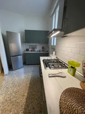 a kitchen with green cabinets and a stove top oven at Anna's House in Rome