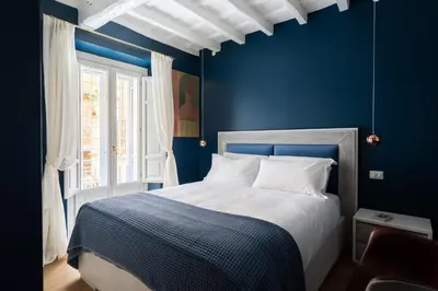 a blue bedroom with a bed and a window at Elegance and Charm in Splendid Via Giulia in Rome