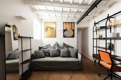 a living room with a couch and a chair at Elegance and Charm in Splendid Via Giulia in Rome