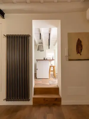 a living room with a radiator and a table at Elegance and Charm in Splendid Via Giulia in Rome