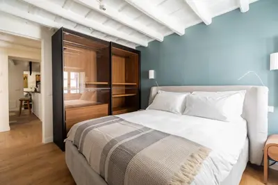 a bedroom with a large white bed and a bathroom at Elegance and Charm in Splendid Via Giulia in Rome