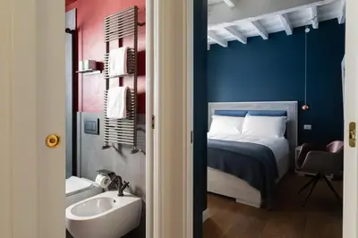 a bathroom with a bed and a sink and a tub at Elegance and Charm in Splendid Via Giulia in Rome