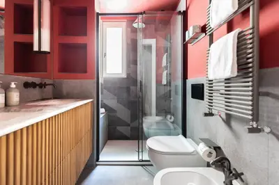 a bathroom with red walls and a toilet and a shower at Elegance and Charm in Splendid Via Giulia in Rome