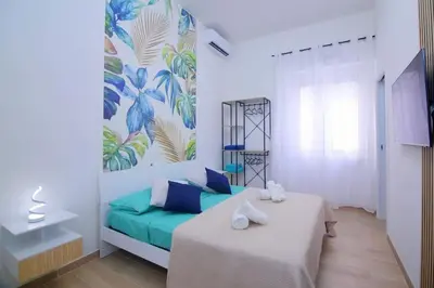 a bedroom with a bed with blue pillows and a mural at Domus green in Rome
