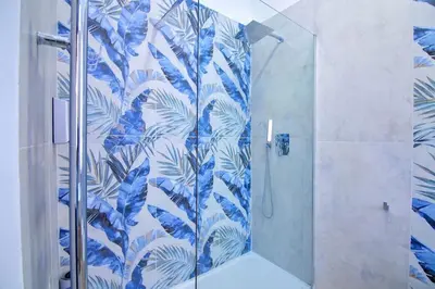 a bathroom with a shower with blue and white wallpaper at Domus green in Rome