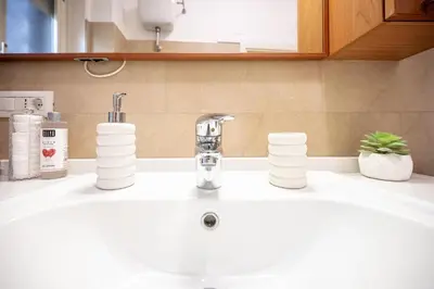 a bathroom sink with a faucet on a counter at King Size Apartment WiFi AIR CONDITIONING TV50 10MIN COLOSSEO-TRASTEVERE in Rome
