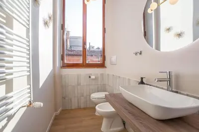 a bathroom with a sink and a toilet and a mirror at Daplace - Romina Apartment in Rome