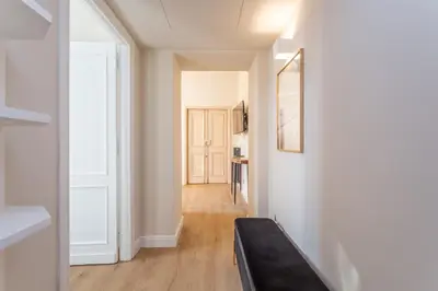 a hallway with a black couch in a white apartment at Daplace - Romina Apartment in Rome