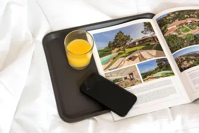 a glass of orange juice on a tray next to a book at Monte Sacro apartment for 6 guests Metro B in Rome