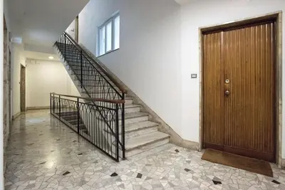 a staircase in a house with a wooden door at Monte Sacro apartment for 6 guests Metro B in Rome