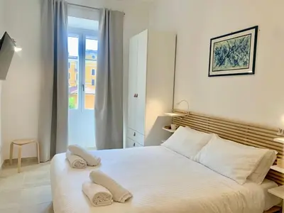a bedroom with a white bed with two towels on it at RomeAsYouLike - Stradivari Charme in Rome
