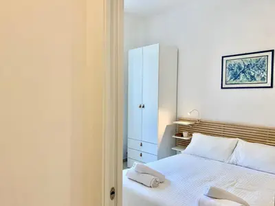 a bedroom with a white bed and a white cabinet at RomeAsYouLike - Stradivari Charme in Rome