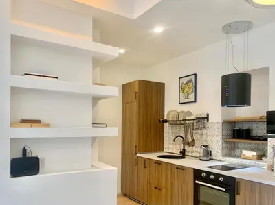a kitchen with white walls and wooden shelves at RomeAsYouLike - Stradivari Charme in Rome
