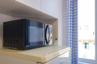 a microwave sitting on a shelf in a kitchen at ht mama bilo vatican area in Rome