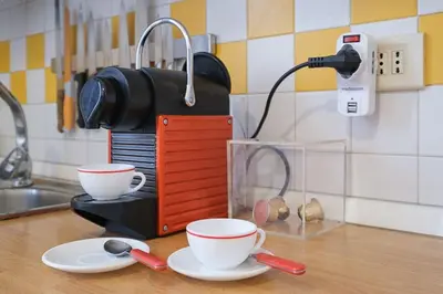 a coffee maker on a counter with two cups on plates at ht mama bilo vatican area in Rome