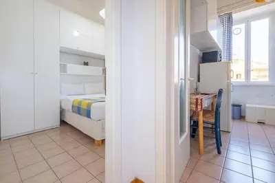 a bedroom with a bed and a desk and a kitchen at ht mama bilo vatican area in Rome