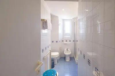 a white bathroom with a toilet and a sink at ht mama bilo vatican area in Rome