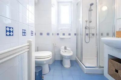 a white bathroom with a toilet and a sink at ht mama bilo vatican area in Rome