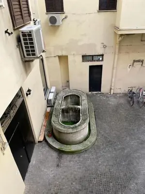 an old boat sitting in a courtyard next to a building at testaccio sei in Rome