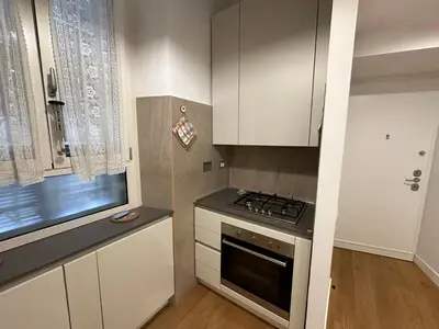 a kitchen with white cabinets and a stove top oven at FL Suites - Vatican in Rome
