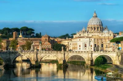 a bridge over a river in front of a city at FL Suites - Vatican in Rome