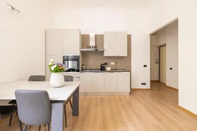 a kitchen with a table with a vase of flowers on it at Elegant Ostiense Suite in Rome