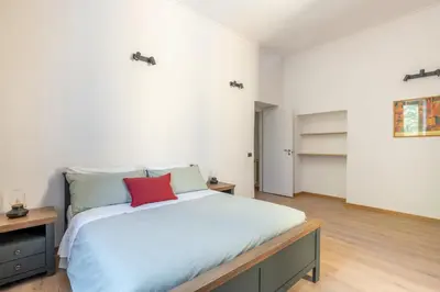 a bedroom with a large bed with a red pillow at Elegant Ostiense Suite in Rome