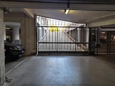 a garage with a gate with a car parked in it at Bright apt near Porta Maggiore in Rome