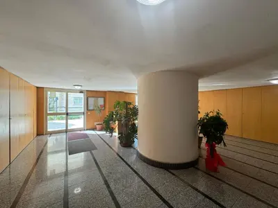 a lobby with a column and potted plants in a building at Bright apt near Porta Maggiore in Rome