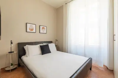 a bedroom with a bed with white sheets and a window at Centro - casa a Trastevere in Rome