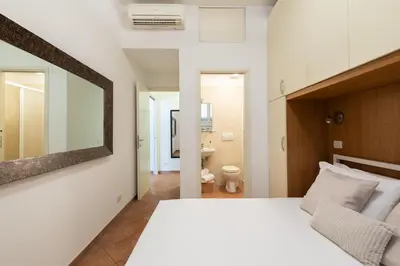 a bedroom with a large white bed and a mirror at Centro - casa a Trastevere in Rome
