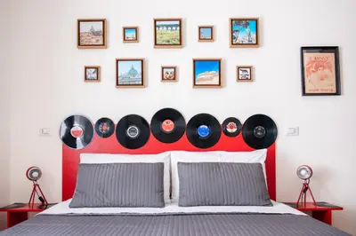 a bedroom with a bed with a bunch of records on the wall at Grammy Suite in Rome