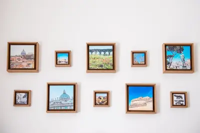 a wall of framed photos on a white wall at Grammy Suite in Rome