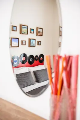a mirror reflecting a room with a bed with records at Grammy Suite in Rome